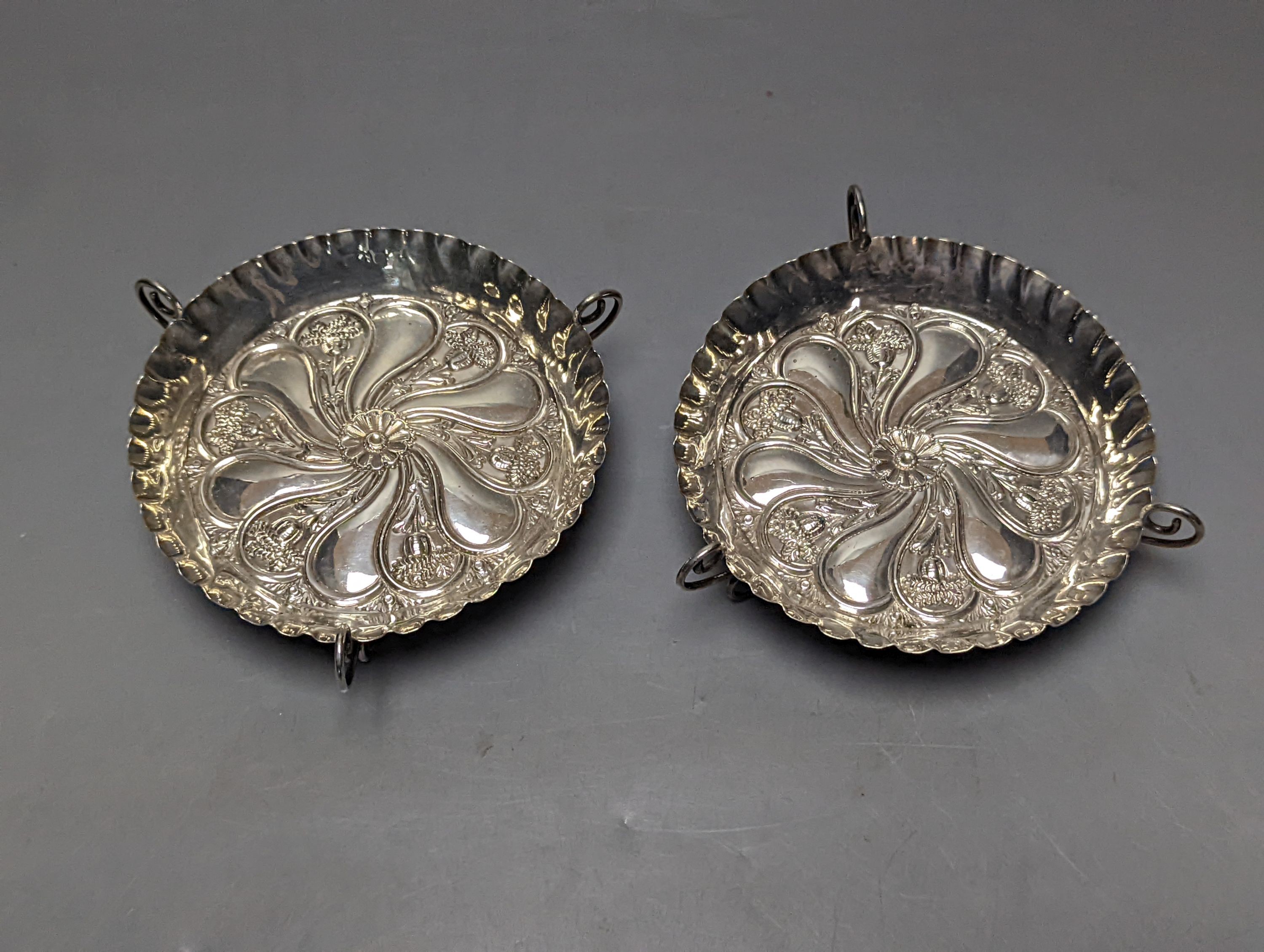 A pair of late Victorian repousse silver tri-handled shallow nut dishes, Vale Brothers & Serman, Birmingham, 1898, 13.7cm, 135 grams.